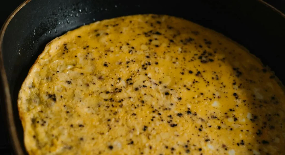 Close-up of batter cooking in a carbon steel skillet