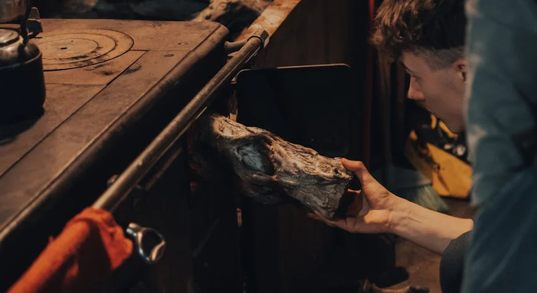 Person holding a cast-iron piece near a stove in a kitchen, illustrating the context of cleaning cast iron.