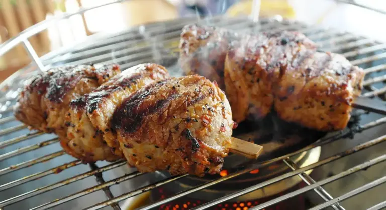 Skewered meat grilling on a cast-iron grill with dark grill marks