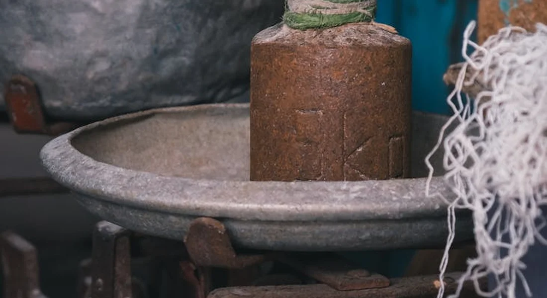 Close-up of a rusty cast-iron stove component next to a metal grate.