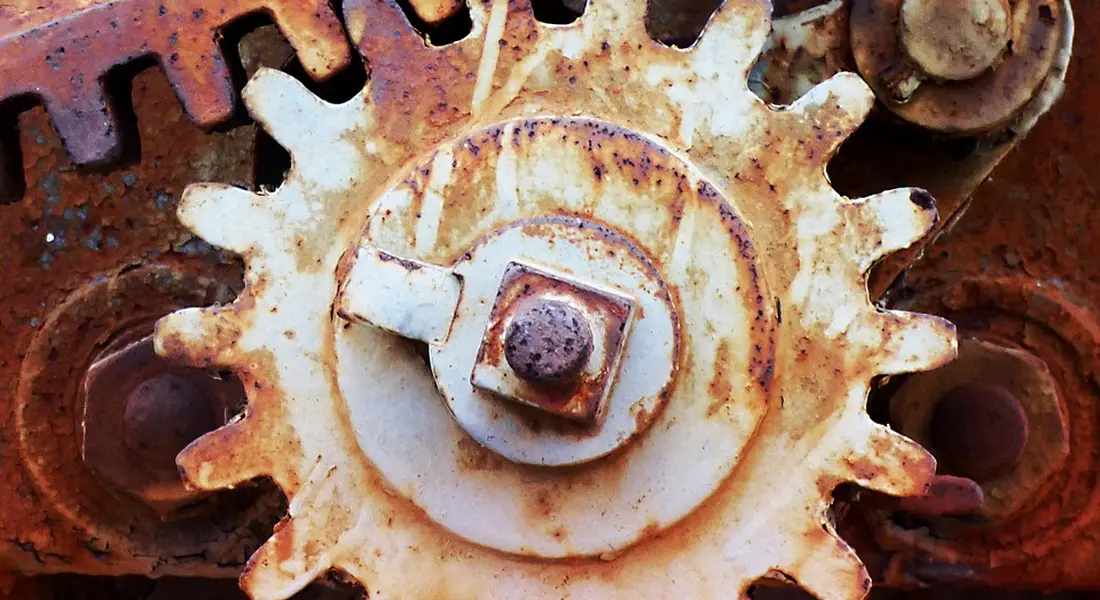Close-up of a rusted gear with orange-brown corrosion, illustrating flash rust on exposed metal.