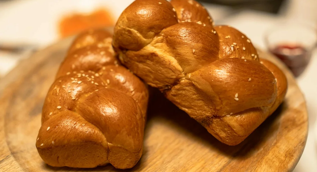 Golden-brown dinner rolls resting on a wooden board