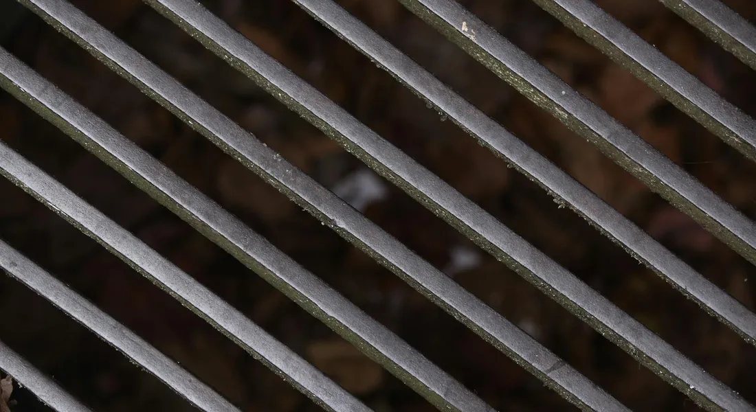 Close-up view of cast iron grill grates with a dark, seasoned surface.