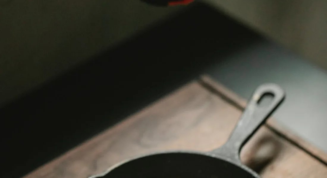 Close-up of a cast iron skillet handle resting on a wooden surface