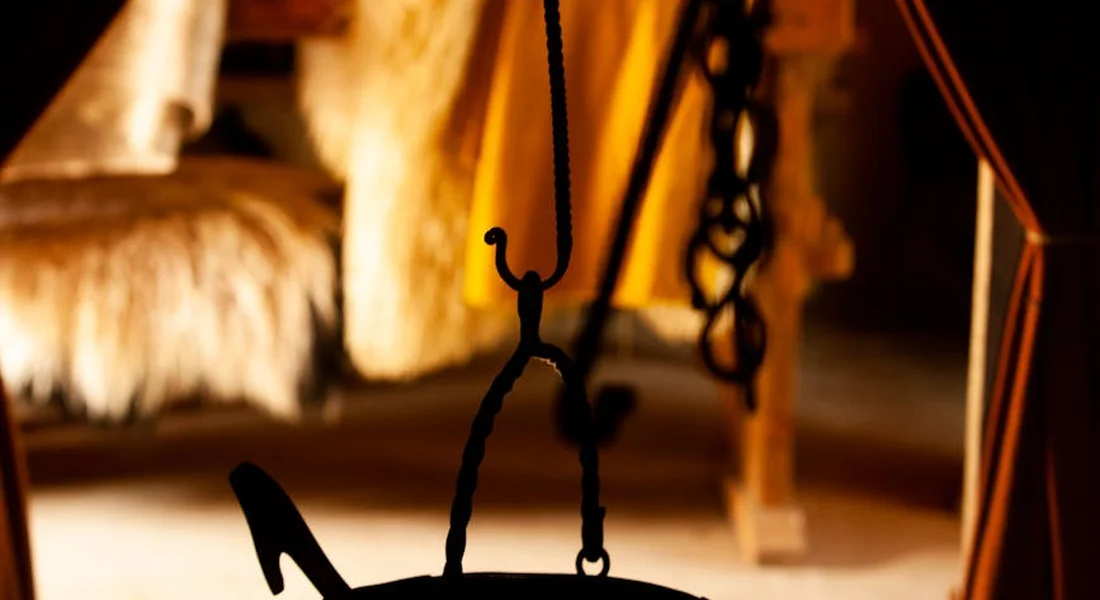 Cast iron cookware hanging on a hook in a warm, rustic kitchen, illustrating prep and readiness.