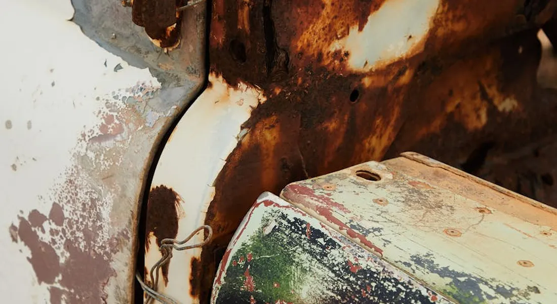 Close-up of a rusted metal surface with peeling paint, illustrating corrosion risk on cast iron.